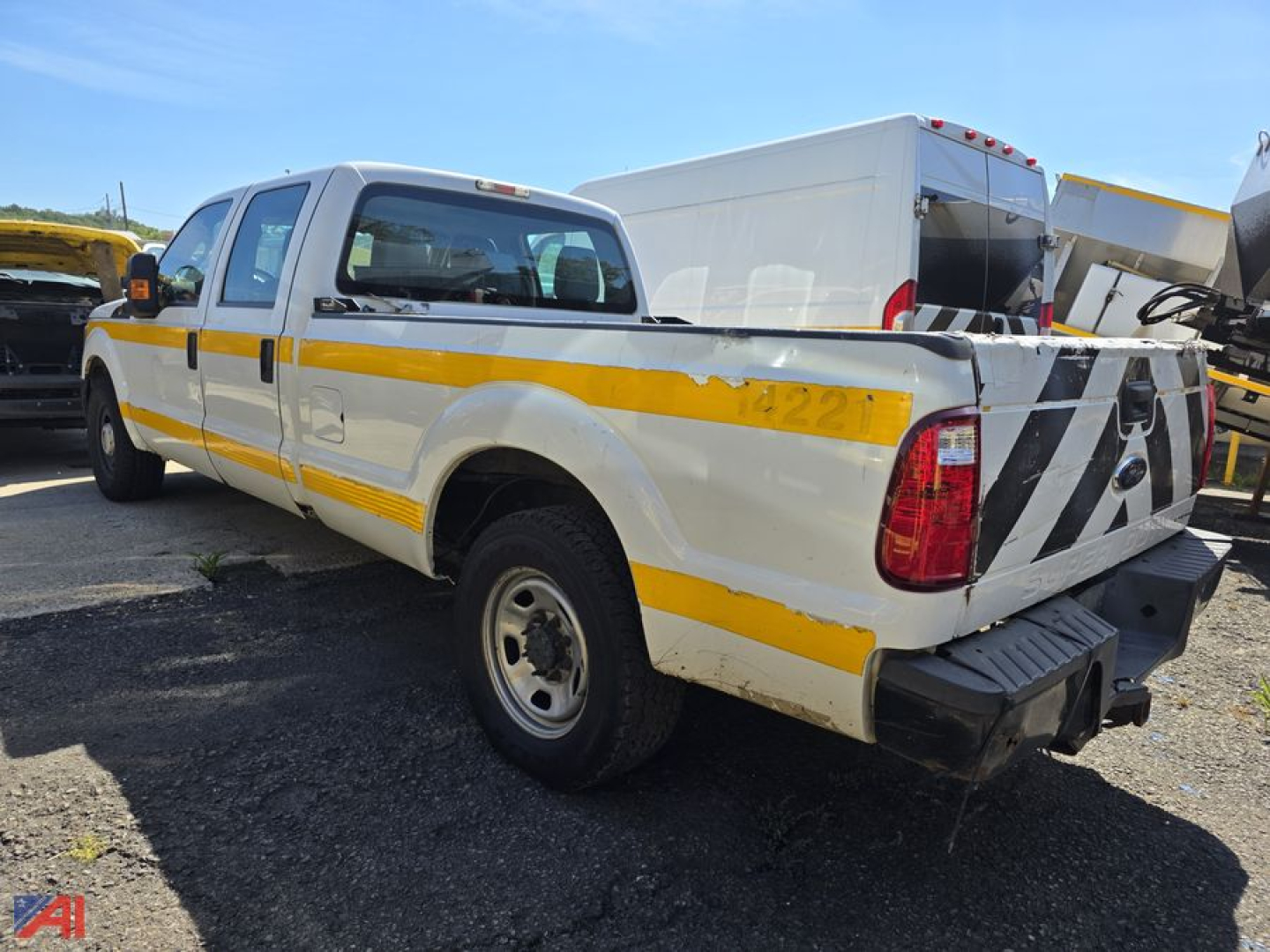 Ford F-350 Super Duty pickup with crew cab and single rear wheel showing rear view with yellow reflective stripe and damaged bed side.