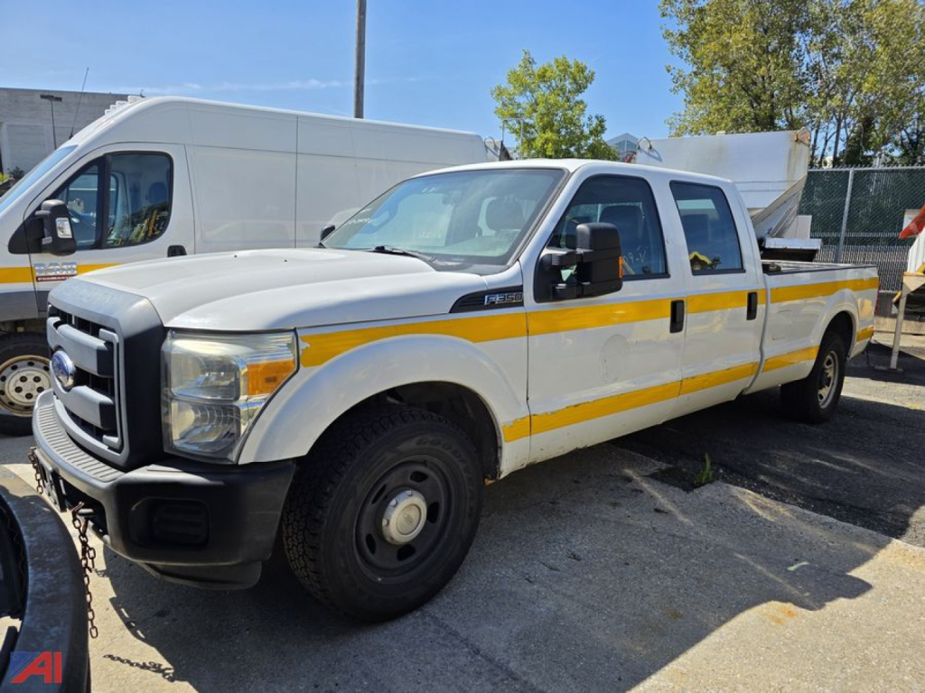 Ford F-350 Super Duty dual rear wheel pickup truck with white body and yellow reflective stripe, long bed, daytime outdoor lot.