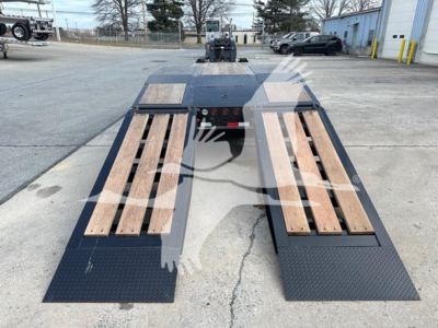 Flatbed trailer with dual ramps and wooden deck boards, rear view showing loading ramp area and wheel wells on each side.