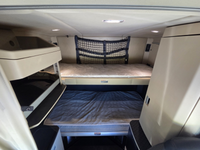 Kenworth W990 sleeper cab interior showing bunk beds and storage nets.