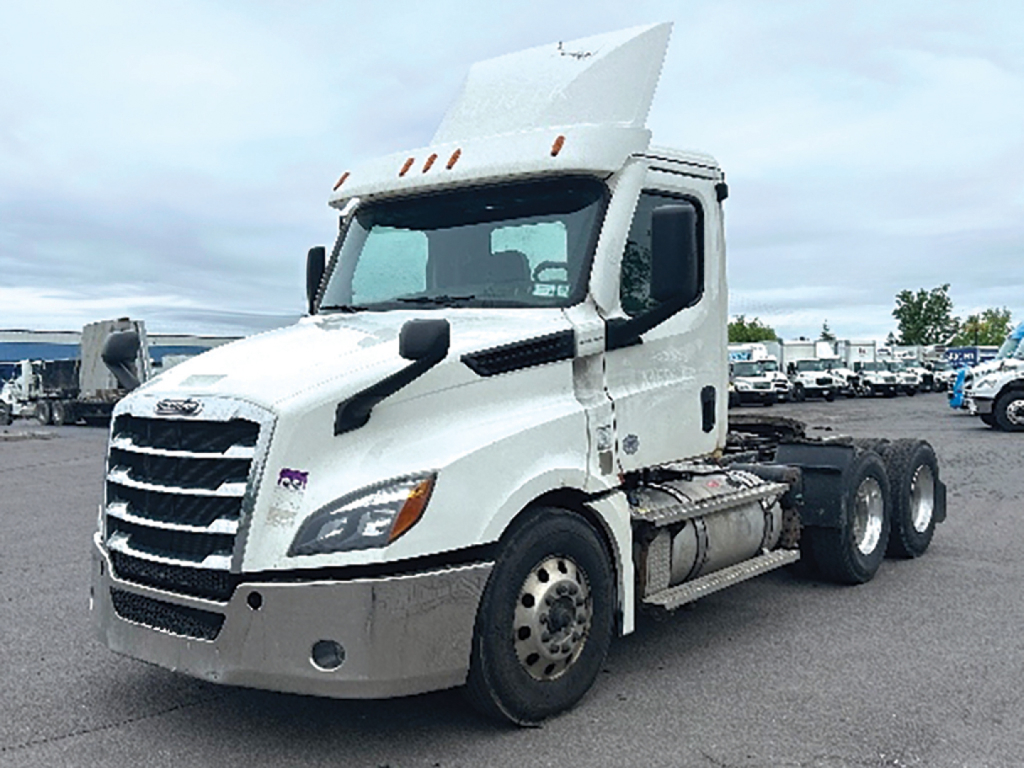 Freightliner Cascadia 126 daycab tractor showing front left side with raised hood and sleeper area, white exterior, dual rear axles, chassis fuel tanks and wheels visible.