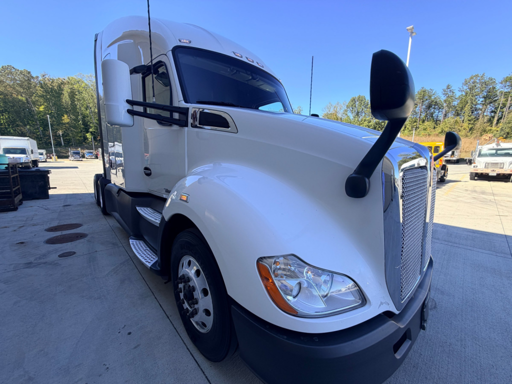 Kenworth T680 conventional sleeper truck in white, front angled view with large side mirrors and chrome grille.