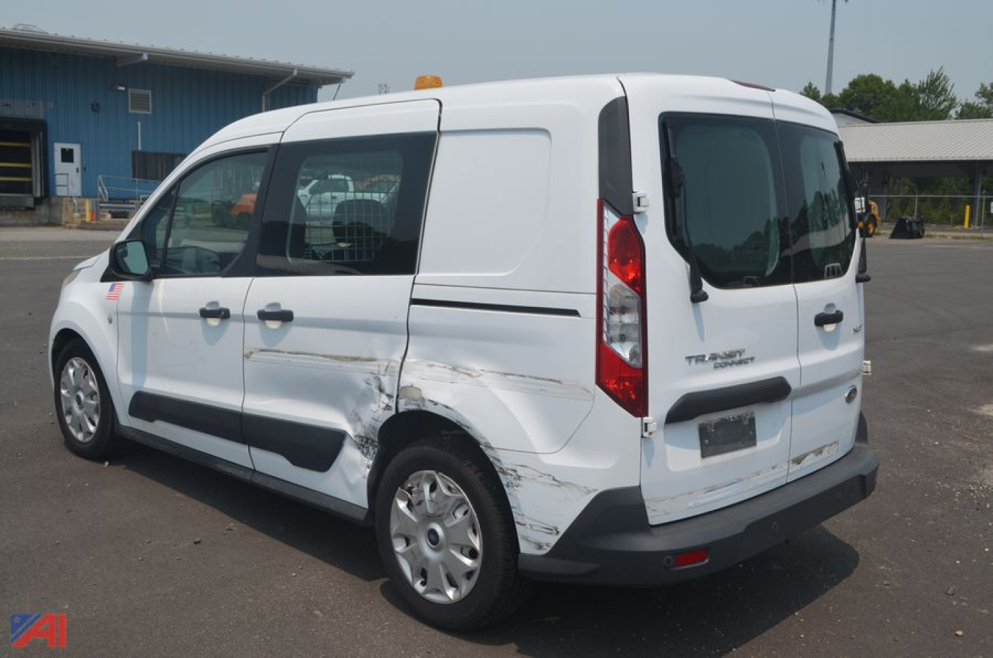 Ford Transit Connect mini-van rear-side view showing body damage on the passenger side and rear bumper.