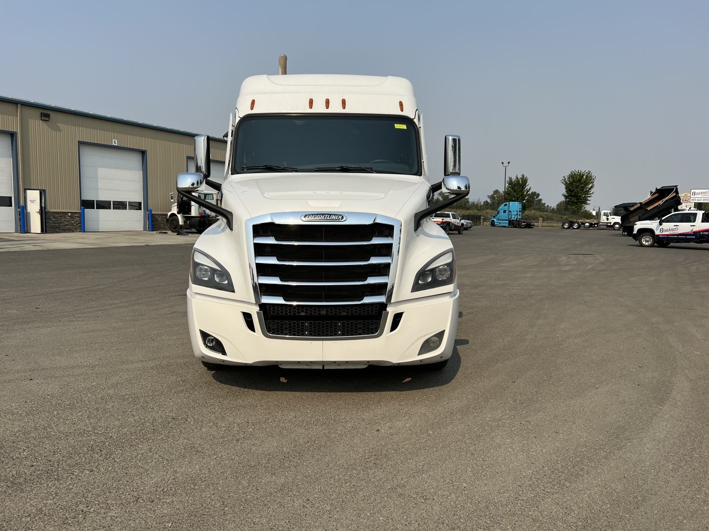 Freightliner Cascadia 126 sleeper tractor facing camera in a lot, front grille, headlights, and bumper visible.