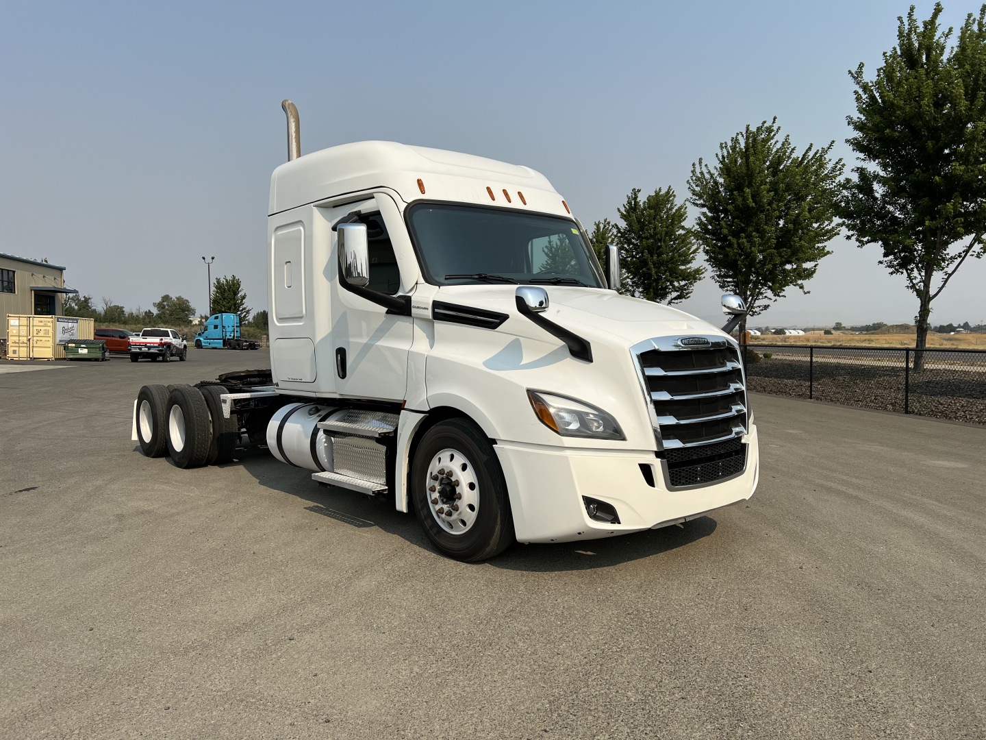 Freightliner Cascadia 126 tractor cab in white, front-side view showing sleeper cab, aerodynamic mirrors, and dual rear axles.