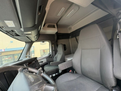 cab interior of a 2020 Freightliner Cascadia 126 truck showing driver seat, steering wheel, dashboard, and overhead storage