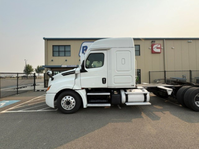 Freightliner Cascadia 126 tractor in side view showing cab, side fuel tanks and bumper with VIN plate visible.