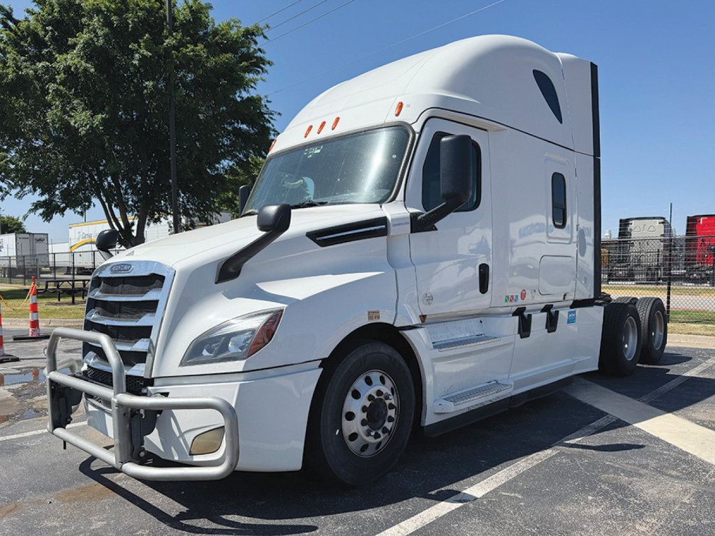 Freightliner Cascadia126 day cab/truck in white, side view showing aerodynamic mirrors, front bumper guard, sleeper cab with raised roof, dual rear axles, and daytime running lights.