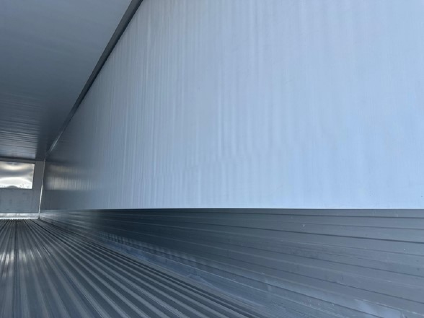 Trailer interior showing corrugated metal walls and floor with light from an opening, empty cargo space in a 2026 Utility 3000R refrigerated trailer.