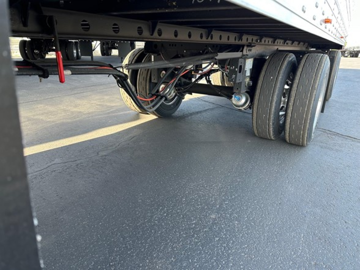 Trailer undercarriage showing dual rear axles, suspension, and wiring of a 2026 Utility 3000R reefer trailer.