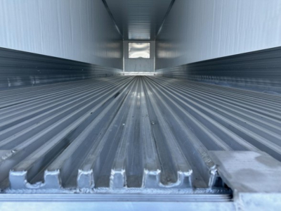 Interior view of a 2026 Utility 3000R trailer dry steel floor with corrugated ribs, bright metal walls, long box interior.