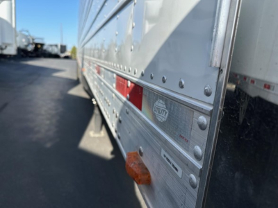 Trailer side view showing metal riveted panel with reflective tape and ULTRA brand plate on a 2026 Utility 3000R reefer trailer.