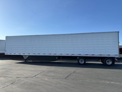 Trailer side view showing a new 2026 Utility 3000R reefer trailer with white corrugated sides, dual rear axles, and no visible branding.