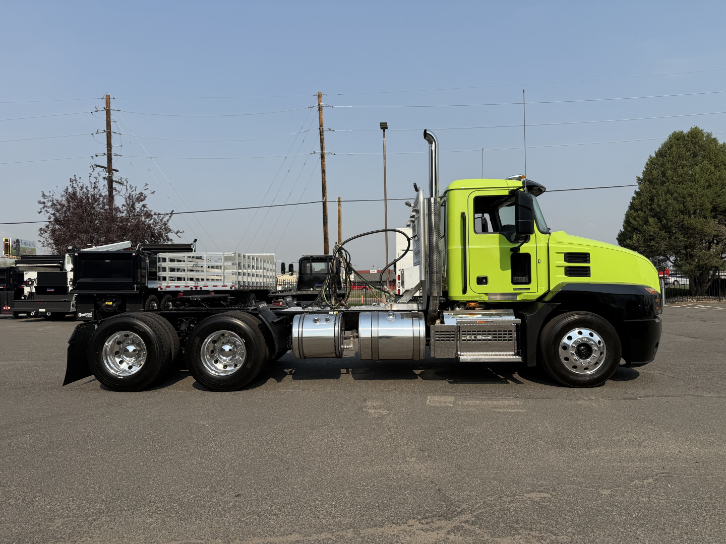 Green Mack AN64T daycab truck side view showing chassis and fuel tanks