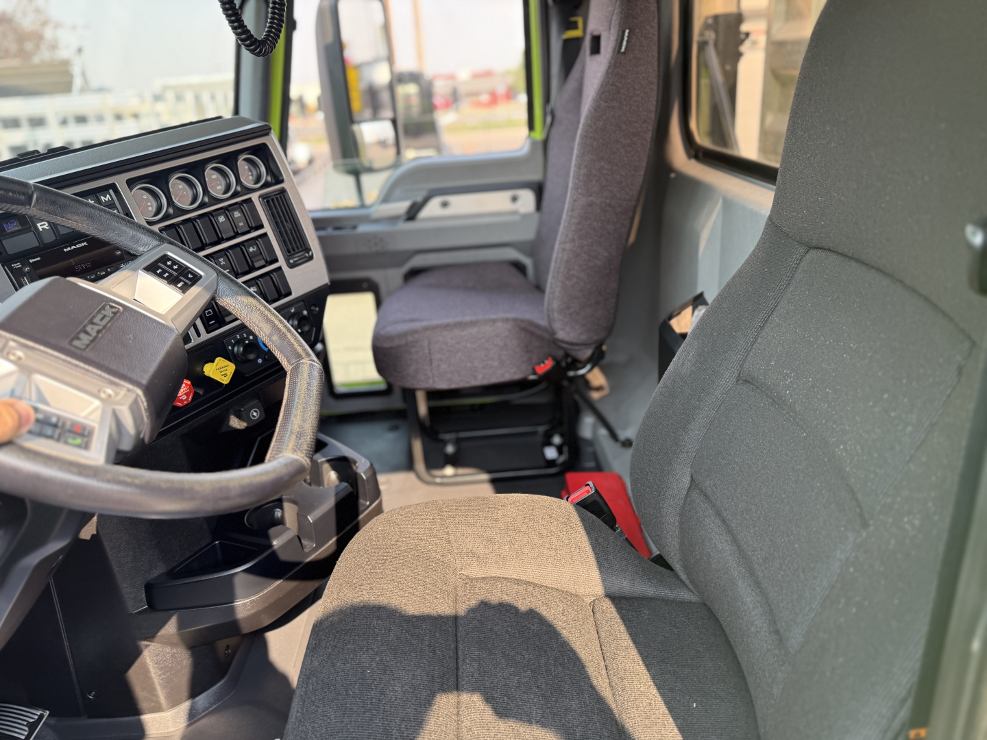 Mack AN64T truck interior showing steering wheel dashboard gauges and driver seat.