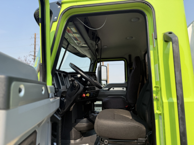 Truck cab interior of a 2025 Mack AN64T conventional daycab showing steering wheel, dashboard, driver seat, and passenger seat with ample legroom.