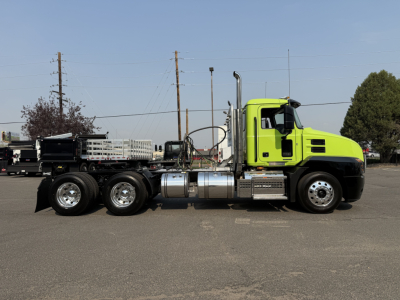 Green Mack AN64T daycab truck side view showing chassis and fuel tanks