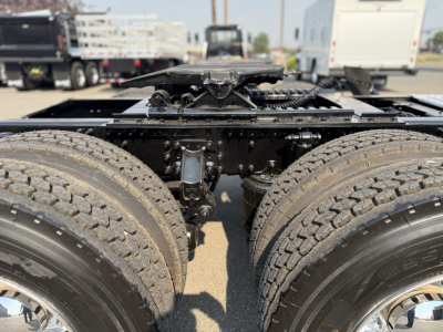 Mack AN64T rear chassis showing dual rear axles and air suspension components with frame and drivetrain visible.