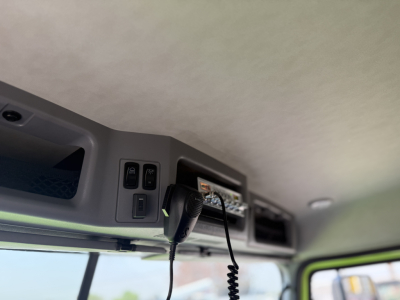 Interior cabin ceiling with control switches and a handheld microphone in a Mack AN64T truck cab.