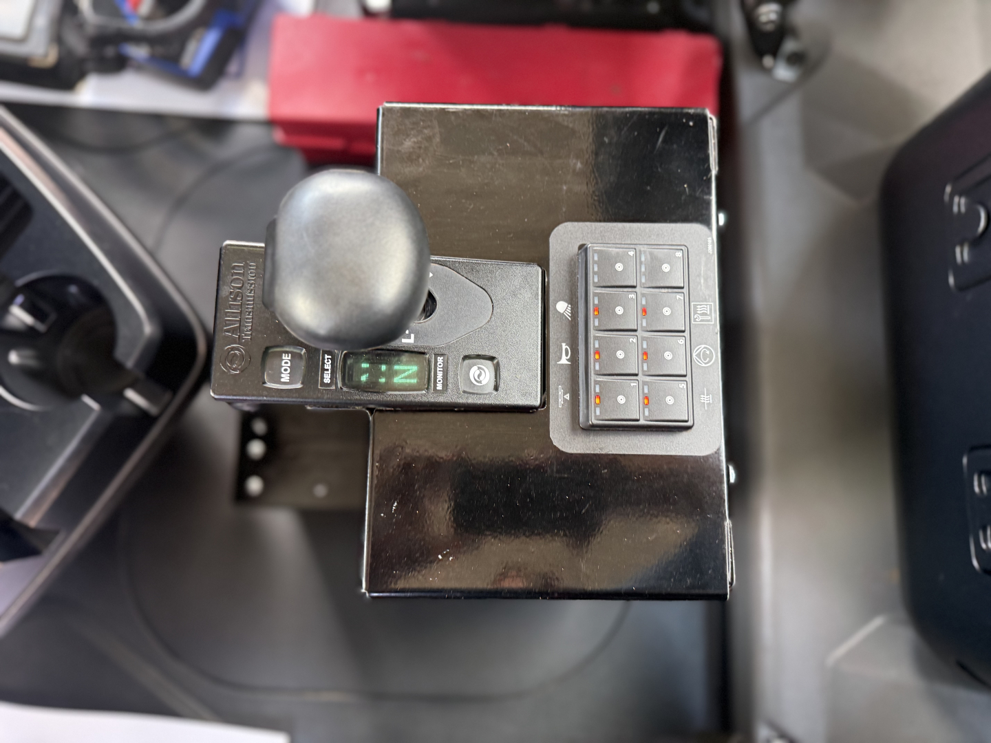 Mack GR64B cab interior showing gear selector with digital shifter and keypad on a black console.
