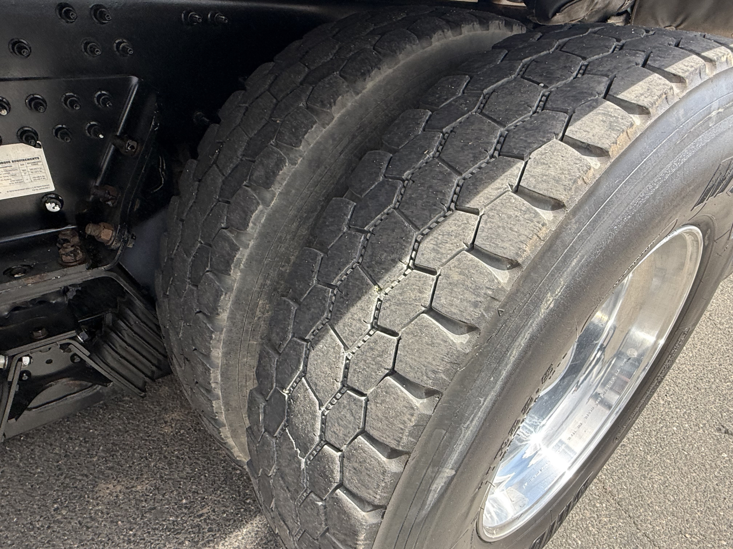 Tire and wheel on Mack GR64B truck showing heavy-duty tread and chrome wheel, undercarriage components visible