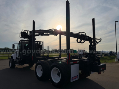 Mack CV713 truck in-service showing grappler arm with hydraulic lines and rear dual rear axles, used condition.