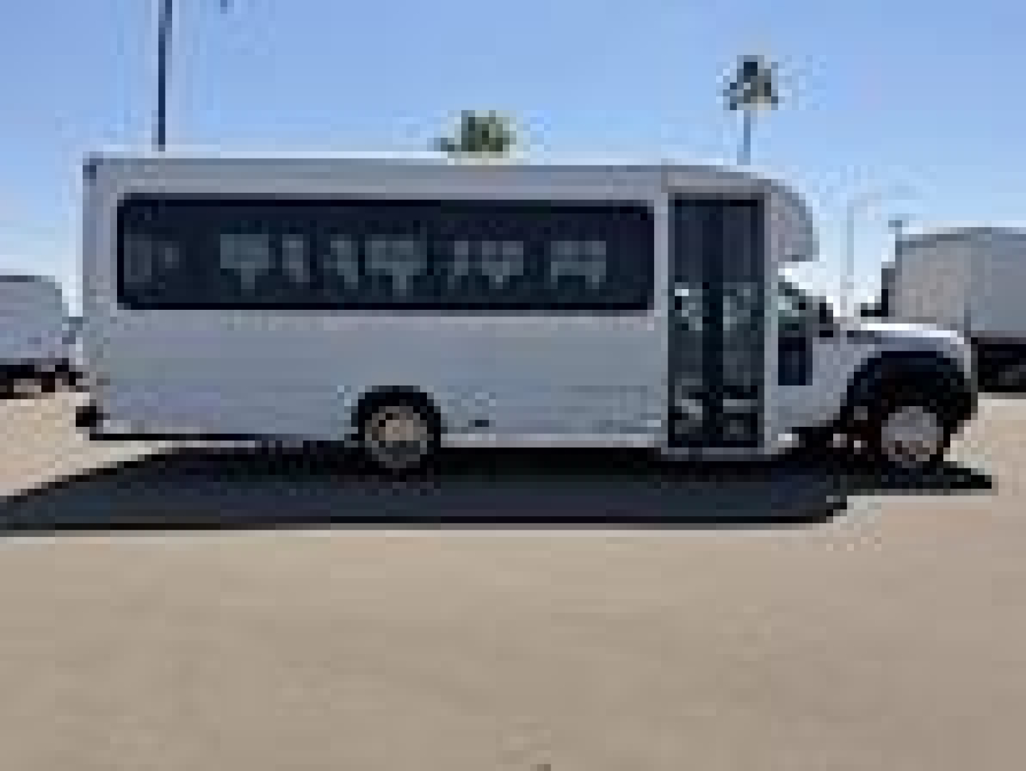 Ford F-450 bus-style shuttle showing side profile with large windowed body and entry door.
