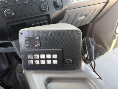 Ford F-450 interior center console with control panel and switches, including a rectangular badge and gear selector nearby.