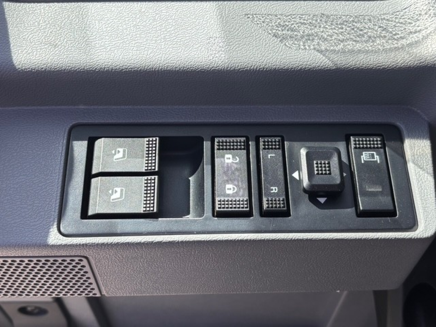 Interior switch panel showing window controls, mirror adjust, and lock switches in a Mack GR64B cab. Contains multiple square buttons with icons.