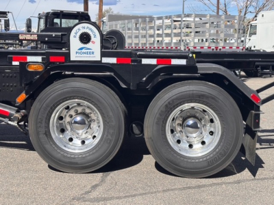 Truck chassis side showing dual rear wheels and frame with Mack GR64B rolling mechanism and equipment rack.