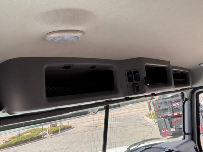 Mack GR64B truck interior upper storage panels and overhead console showing compartments and controls.