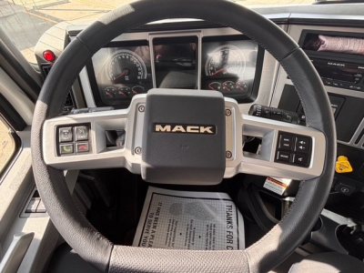 Mack GR64B truck steering wheel and dashboard with Mack logo on center hub.
