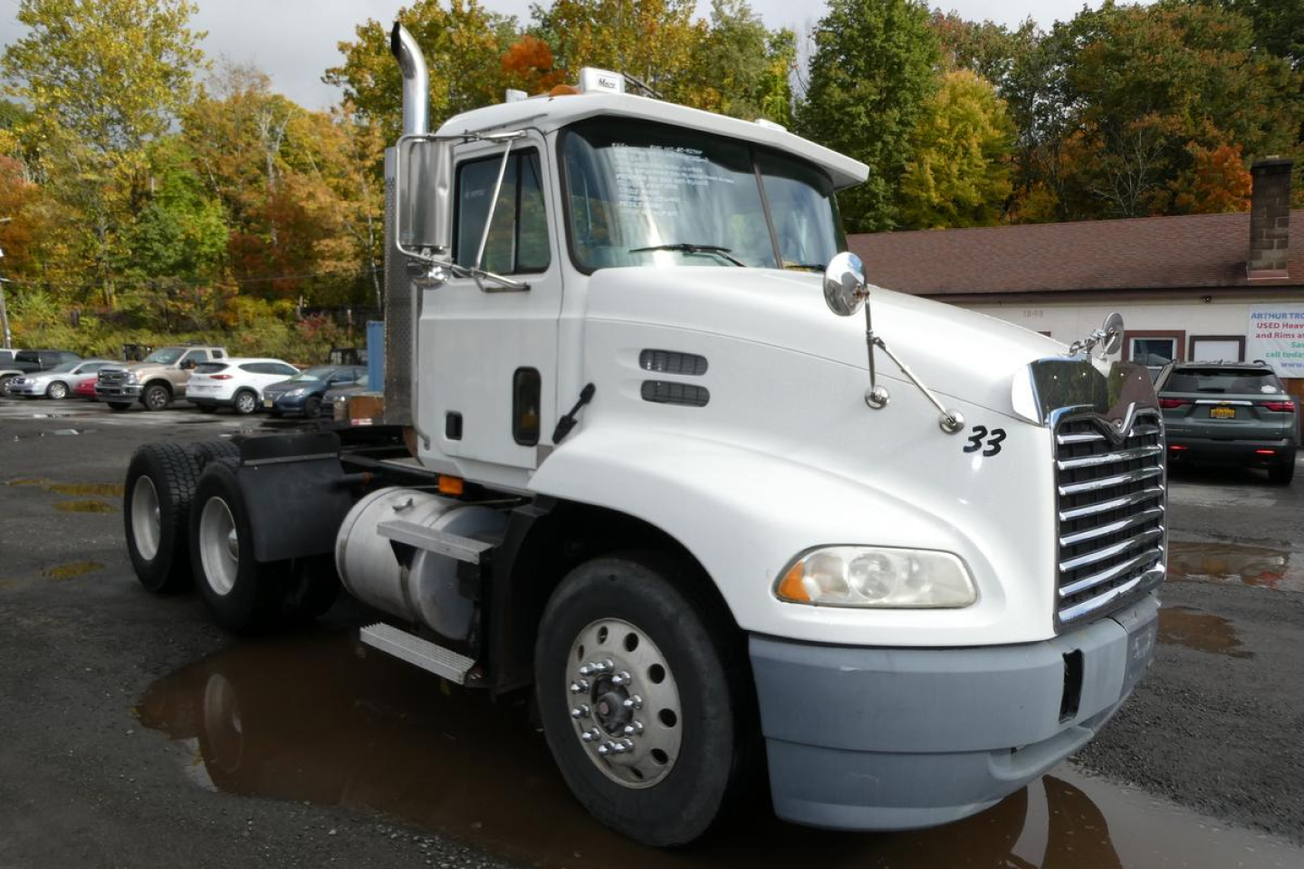 White 2004 Mack CX Vision CX613 daycab truck side view showing cab, grille, and front wheel with 33 decal.
