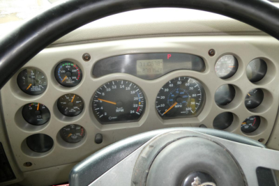 Dashboard of a Mack CX truck showing gauges and digital display with various indicators.