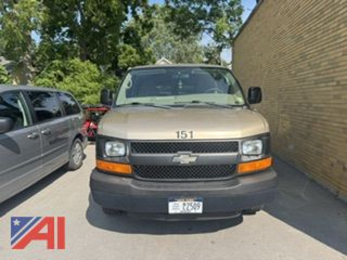Front view of a 2012 Chevrolet Express LS2500 cargo van with tan/beige paint, black grille, Chevrolet emblem, and California license plate.