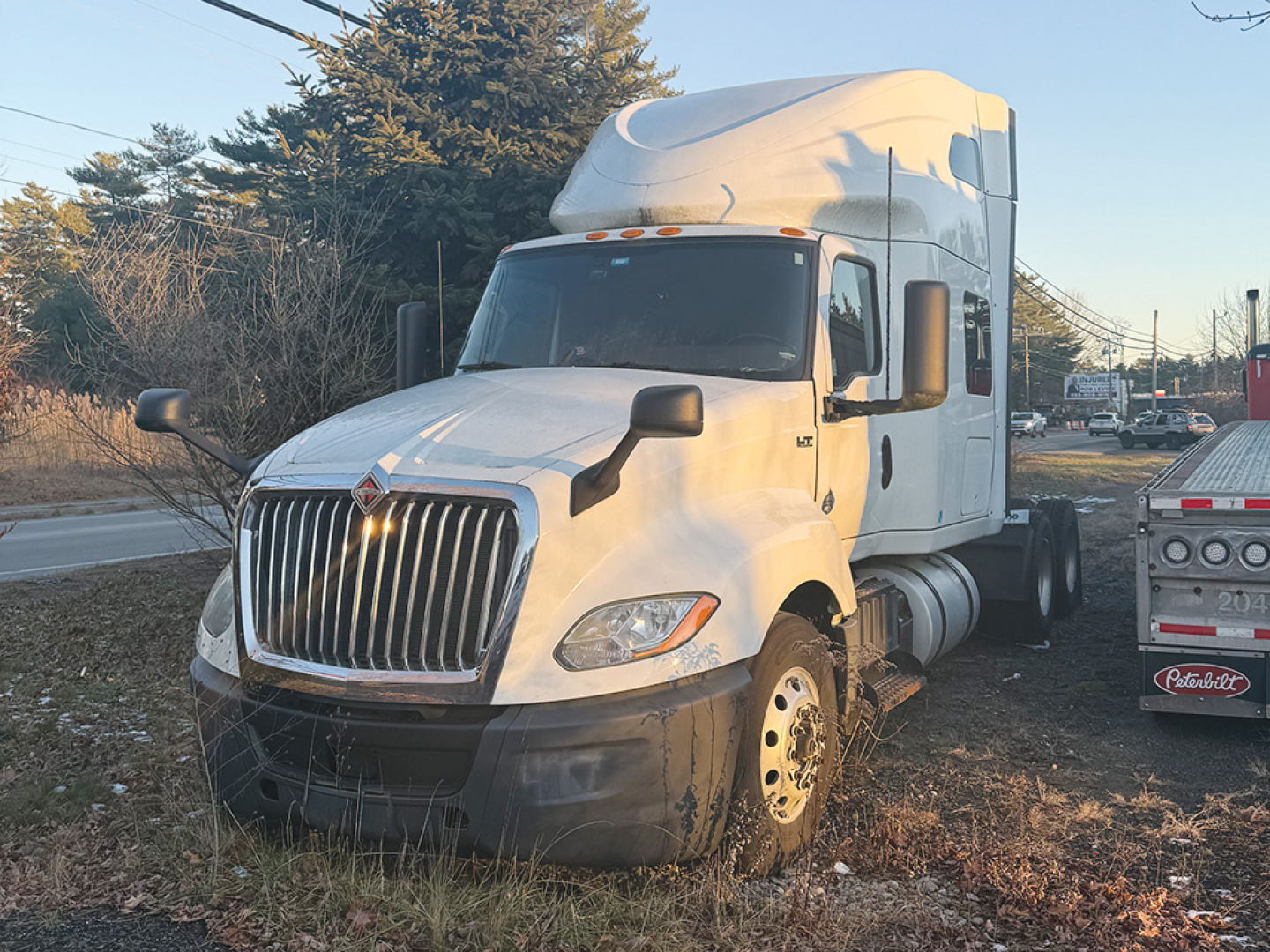 International LT625 truck in view showing front grille and cab with sleeper, no visible text on components.