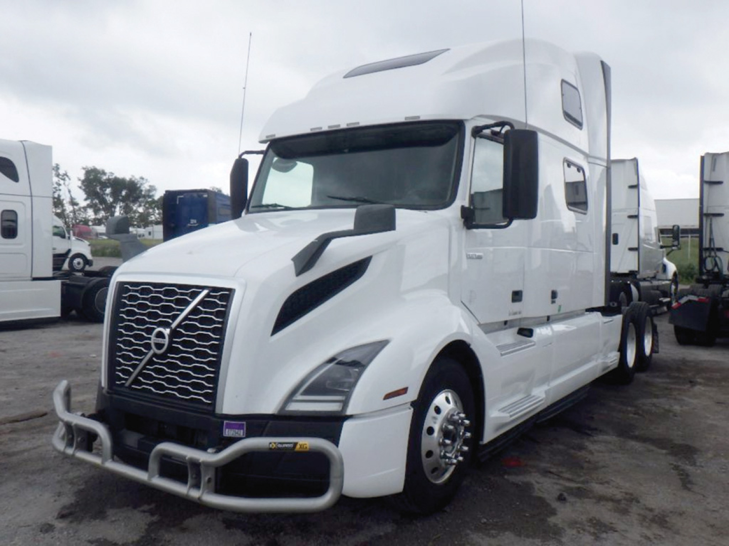 Volvo VNL 860 sleeper cab truck in white, front grille with Volvo emblem, large bumper guards, and side mirrors.