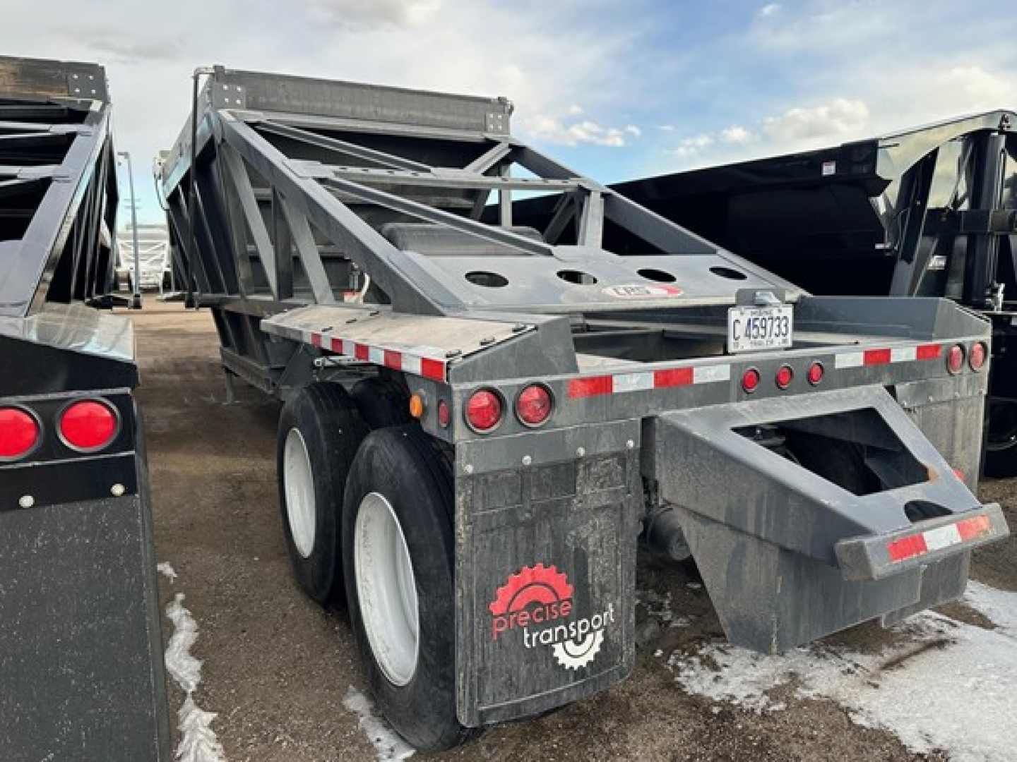 Trailer rear view of a 40' air ride bottom dump with dual rear axles and Precise Transport logo on mud flaps.