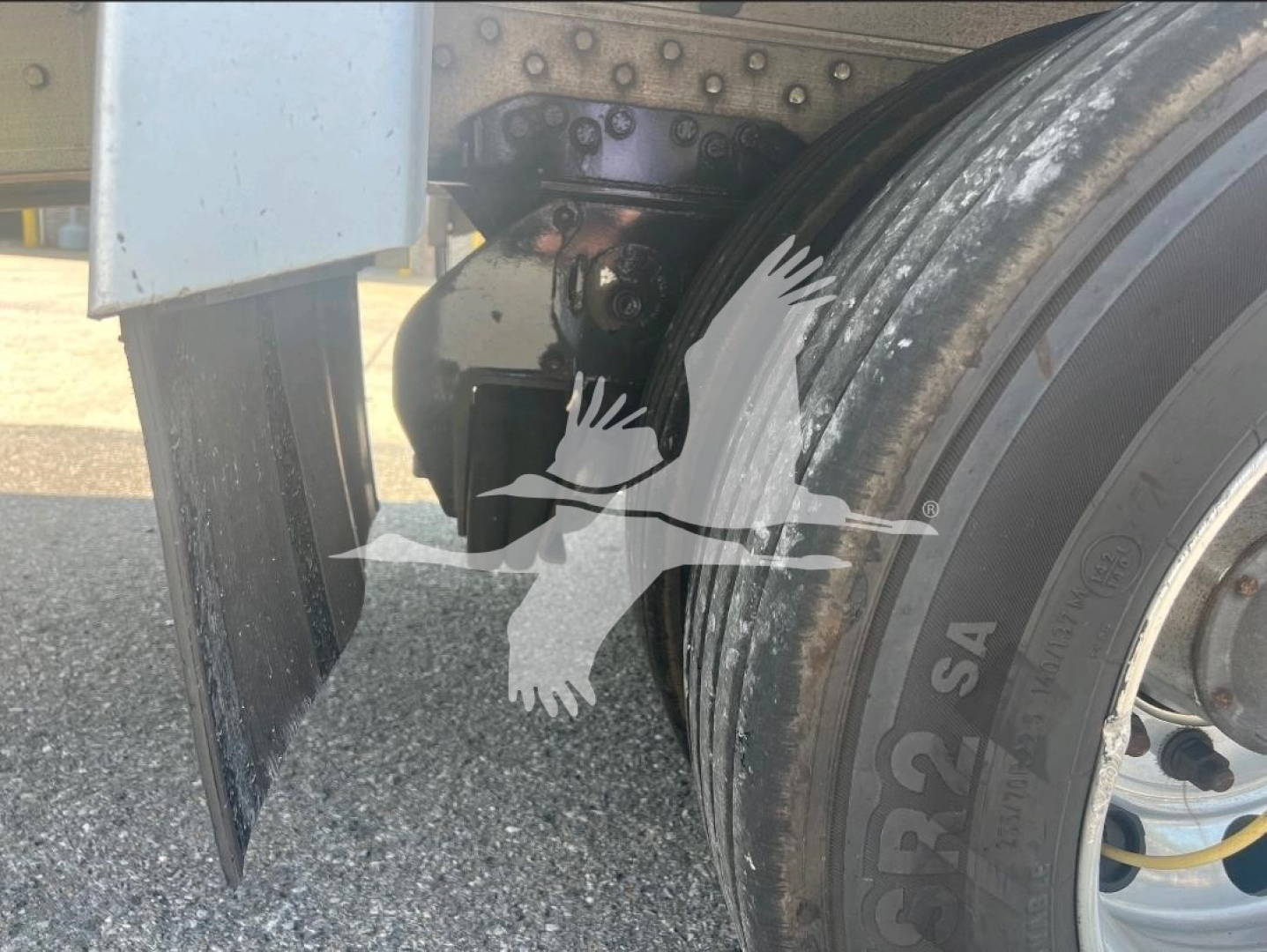 Trailer wheel area showing dual tires with mudflap and suspension hardware from a 2021 Reitnouer dropdeck trailer.