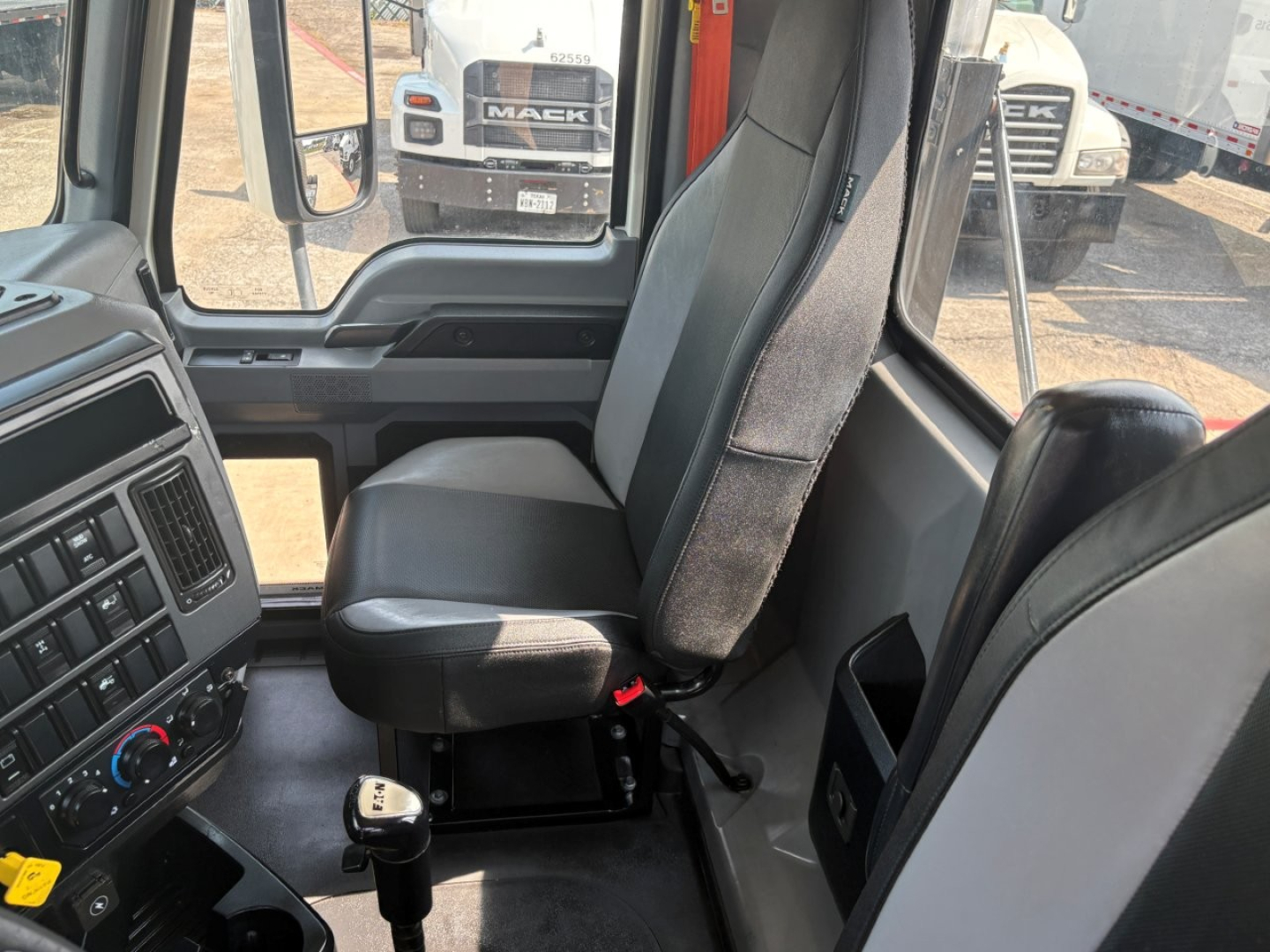 Cab interior of a 2020 Mack PI64T daycab showing driver seat, steering wheel area, and dash cluster with transmission gear knob visible.