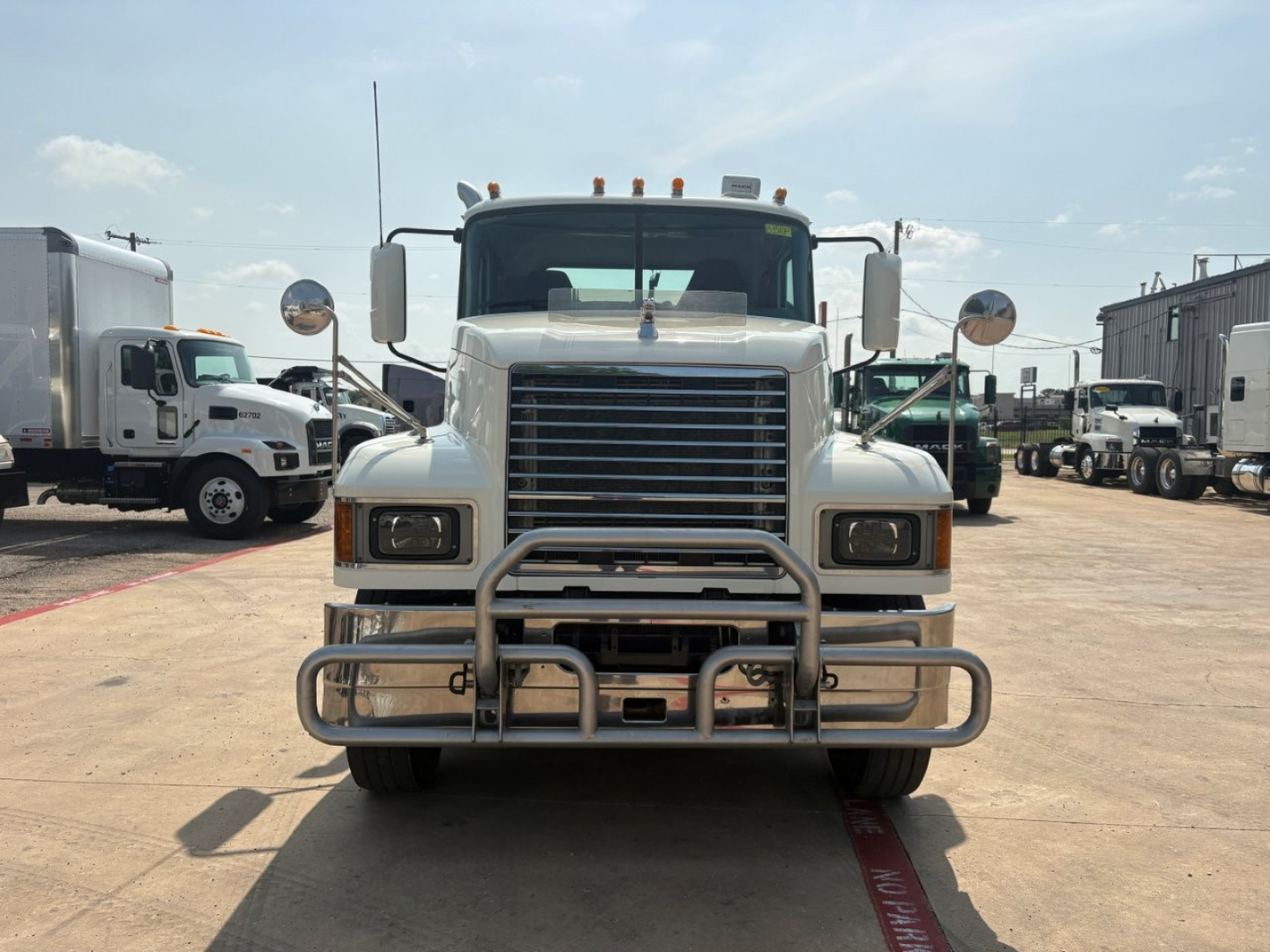 Mack PI64T conventional day cab front view showing large chrome grille, bumper guard, and dual headlights.