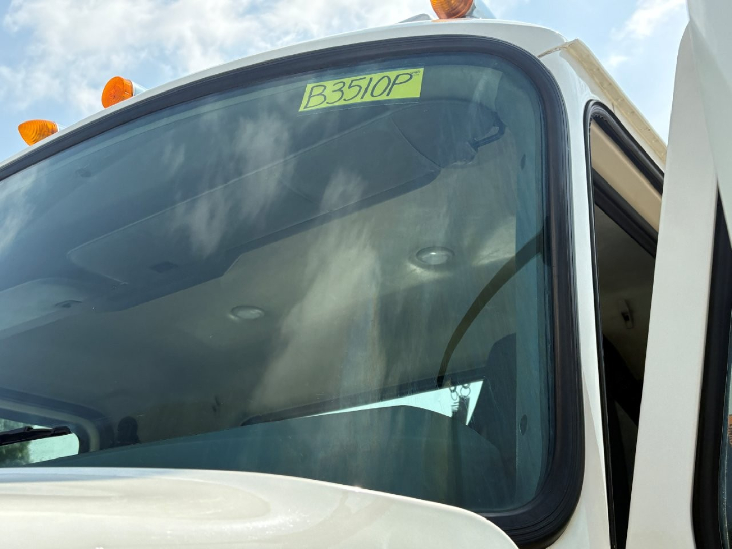 Truck cab scene showing windshield with a yellow tag reading B3510P on a 2020 Mack PI64T exterior.