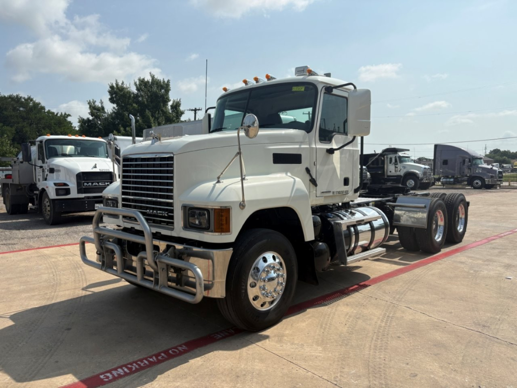 Truck shown from front-left angle with large grille, bumper guard, and dual rear axles. Exterior white cab, chrome wheels, and fuel tanks visible. No legible text identified in image.