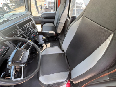 Cab interior of a 2020 Mack PI64T truck showing driver seat and passenger seat, steering wheel with Mack logo, dashboard controls, and center console.