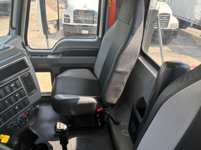 Cab interior of a 2020 Mack PI64T daycab showing driver seat, steering wheel area, and dash cluster with transmission gear knob visible.
