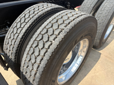Mack PI64T truck chassis showing dual rear wheels with treaded tires and chrome rims.