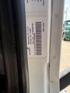 Mack PI64T truck identification label on door frame showing model, VIN, and other codes.