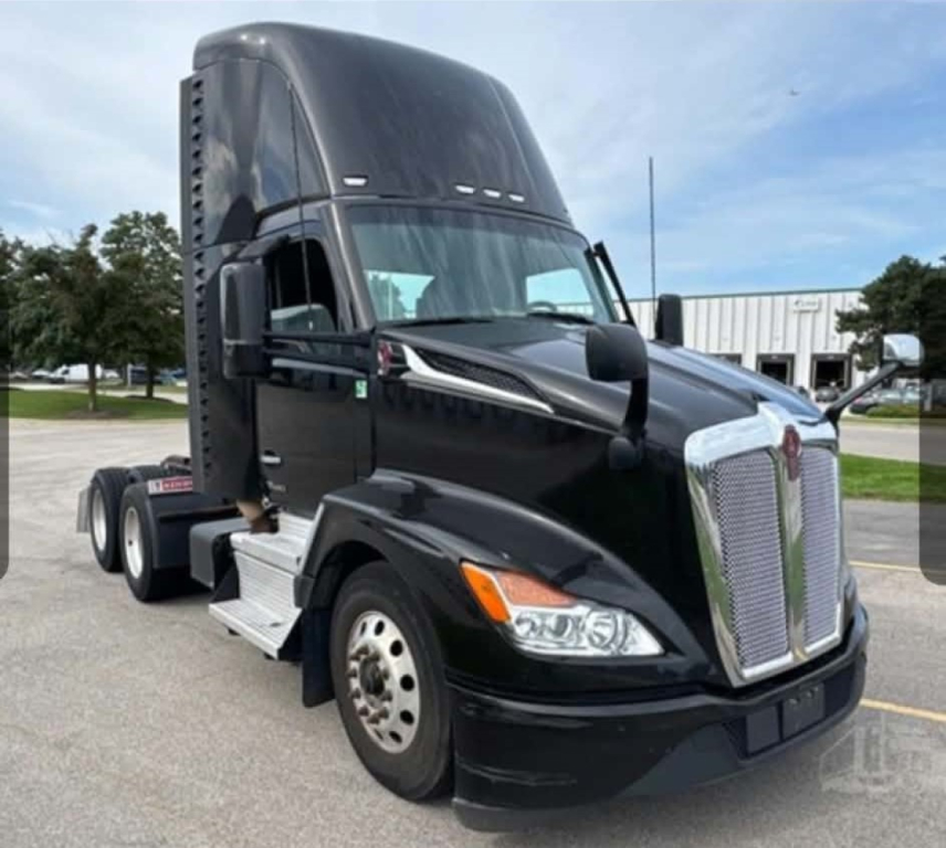 Kenworth T680 side view showing sleeper cab, black exterior, chrome grille, dual rear axles, front headlight cluster.