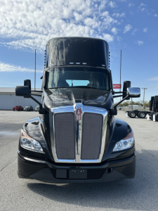 Kenworth T680 front view showing chrome grille, large black hood, and headlights; no visible text on the image other than the vehicle’s design elements.