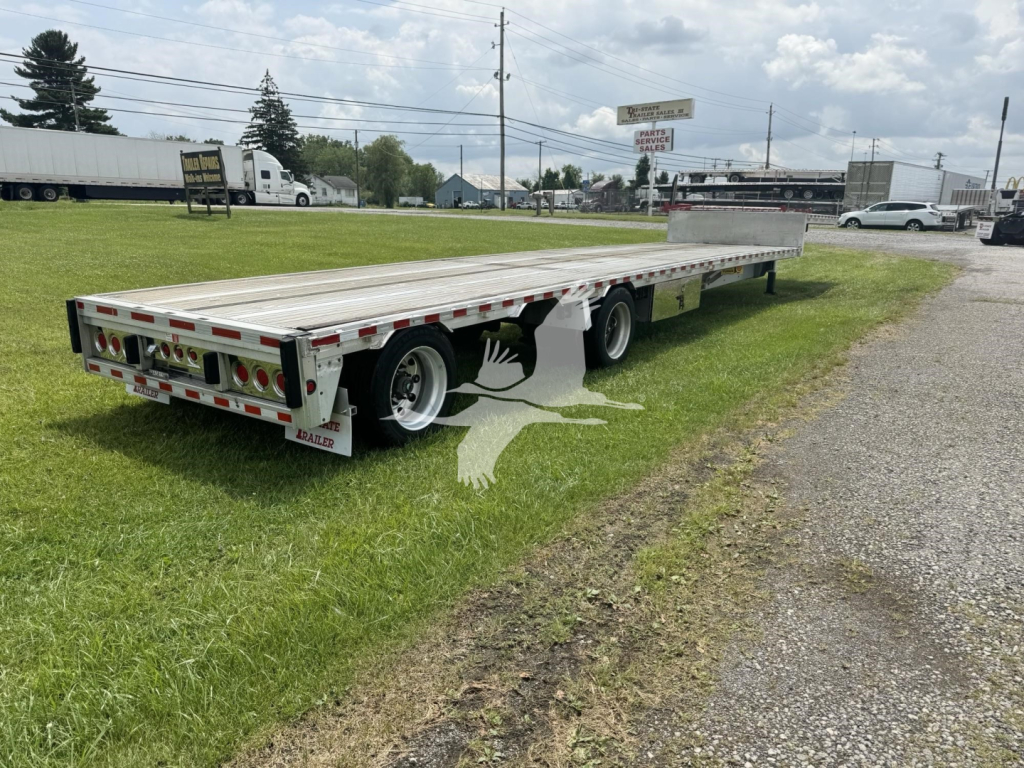 Trailer with flatbed/DropDeck showing rear and side rails, tandem axles, and bumper with taillights.
